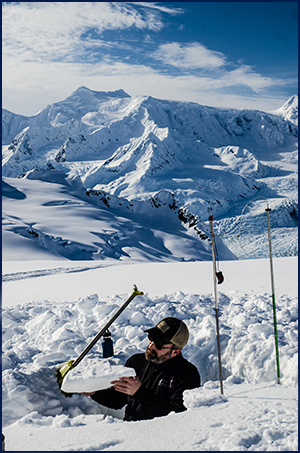 Chris checks the snow for avalanche avoidance